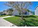 Charming single-story home with manicured lawn and tree in front at 15408 Trinity Fall Way, Bradenton, FL 34212