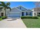 Charming single-story home featuring a well-manicured lawn and attached two-car garage at 15408 Trinity Fall Way, Bradenton, FL 34212