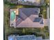 Birds eye view of a well kept backyard, pristine pool, covered patio, and lush landscaping at 1702 4Th St E E St, Palmetto, FL 34221