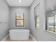 Bright bathroom features a modern soaking tub with windows and neutral tile at 1702 4Th St E E St, Palmetto, FL 34221
