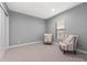 Bedroom with neutral carpet, two arm chairs, and a window at 1702 4Th St E E St, Palmetto, FL 34221