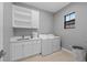 Laundry room with sink, storage, front load washer and dryer, and tile flooring at 1702 4Th St E E St, Palmetto, FL 34221