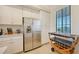 Kitchen area featuring stainless steel refrigerator, cabinetry, and rolling wine rack near a window at 17510 Gawthrop Dr # 305, Bradenton, FL 34211