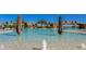 Resort-style pool featuring clear, shallow water, palm trees, and rock waterfall features for leisure and recreation at 17510 Gawthrop Dr # 305, Bradenton, FL 34211