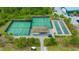 Aerial view of tennis courts and bocce ball with shade pavilion in a wooded area at 17510 Gawthrop Dr # 305, Bradenton, FL 34211