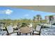 Balcony seating area with a view of the nearby park, foliage, and high-rise building at 1800 Benjamin Franklin Dr # B308, Sarasota, FL 34236