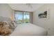Comfortable bedroom features a large bed, sunny view, and neutral colors at 1800 Benjamin Franklin Dr # B308, Sarasota, FL 34236