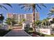 View of the L'Elegance condos through manicured landscaping and palm trees at 1800 Benjamin Franklin Dr # B308, Sarasota, FL 34236