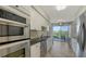 Modern kitchen featuring stainless steel appliances, white cabinetry, and a view to the balcony at 1800 Benjamin Franklin Dr # B308, Sarasota, FL 34236