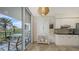 Eat-in kitchen with white cabinetry, stainless appliances, and sliding doors to balcony with views at 1800 Benjamin Franklin Dr # B308, Sarasota, FL 34236