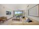 Bright living room featuring stylish furniture, neutral colors, and sliding glass doors to balcony at 1800 Benjamin Franklin Dr # B308, Sarasota, FL 34236