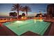 A luxurious pool illuminated at dusk, surrounded by palm trees and beach with lounge chairs and ocean view at 1800 Benjamin Franklin Dr # B308, Sarasota, FL 34236