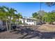 Landscaped backyard featuring tropical plants, mature trees, and outdoor seating area on a sunny day at 2213 Wason Rd, Sarasota, FL 34231