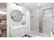 Modern bathroom featuring tiled shower, vanity with a round mirror, and stylish fixtures at 2213 Wason Rd, Sarasota, FL 34231