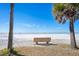 Beach with white sands, clear water, and a bench at 2213 Wason Rd, Sarasota, FL 34231