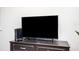 Entertainment setup with a large flat-screen TV and gaming console on a wooden dresser at 2213 Wason Rd, Sarasota, FL 34231