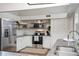 Well-lit kitchen featuring stainless steel appliances, white cabinets, and granite countertops for a clean and functional design at 2213 Wason Rd, Sarasota, FL 34231