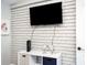 Entertainment area with a mounted TV, stylish shelving, and decorative items on a white brick wall at 2213 Wason Rd, Sarasota, FL 34231