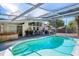 Enclosed pool area with dining and cooking area featuring a jacuzzi and lush surroundings at 2213 Wason Rd, Sarasota, FL 34231
