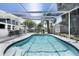 Sparkling screened-in pool offers a refreshing escape, complemented by a shaded patio and lush greenery in the backyard at 2213 Wason Rd, Sarasota, FL 34231