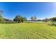 Large backyard with lush green grass, trees, and view of a pond at 2233 Beneva Ter # 2232, Sarasota, FL 34232