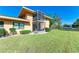 Backyard featuring the two story home, a screened in balcony, and lush green grass at 2233 Beneva Ter # 2232, Sarasota, FL 34232