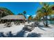 Inviting outdoor beach bar featuring tiki hut and picnic tables on sandy ground, perfect for relaxation at 2233 Beneva Ter # 2232, Sarasota, FL 34232