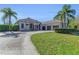 Beautifully designed single-Gathering home with a long driveway, a well-manicured lawn, and a three-car garage at 22354 Panther Loop, Bradenton, FL 34202