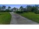 Charming home features a stone facade, three-car garage, and palm trees in a well manicured yard at 22354 Panther Loop, Bradenton, FL 34202