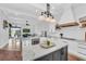 Open-concept kitchen with island, stainless appliances, custom cabinets, and connecting living area at 22354 Panther Loop, Bradenton, FL 34202