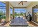 Large covered patio with an outdoor kitchen, dining area, and screened-in views of the backyard and surrounding nature at 22354 Panther Loop, Bradenton, FL 34202
