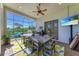 Spacious covered patio with a ceiling fan, outdoor dining set, and a screen offering views of the beautiful landscape at 22354 Panther Loop, Bradenton, FL 34202