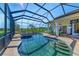 Beautiful screened-in pool with a stone hot tub, brick paver deck, and clear blue water, perfect for outdoor entertaining at 22354 Panther Loop, Bradenton, FL 34202