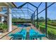 Relaxing pool area with lounge chairs, a screened-in enclosure, stone hot tub, and a beautifully landscaped backyard at 22354 Panther Loop, Bradenton, FL 34202