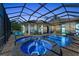 This screened-in lanai features a beautiful custom pool and spa with brick pavers and a covered seating area at 22354 Panther Loop, Bradenton, FL 34202