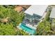 Aerial view of the modern home highlighting the pool, balconies, and surrounding lush greenery at 2327 Hillview St, Sarasota, FL 34239