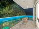 Outdoor balcony features seating and views of the backyard with lit glass railings at night at 2327 Hillview St, Sarasota, FL 34239