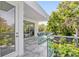 Outdoor balcony with glass railings featuring outdoor seating and views of mature trees at 2327 Hillview St, Sarasota, FL 34239