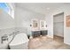 Bright bathroom boasts a soaking tub, dual floating vanities, and stylish, well-lit mirrors at 2327 Hillview St, Sarasota, FL 34239