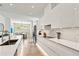 Contemporary kitchen boasts sleek white cabinetry, quartz countertops and stainless steel appliances at 2327 Hillview St, Sarasota, FL 34239