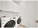 Well-equipped laundry room with LG washer and dryer, and white storage cabinets above at 2327 Hillview St, Sarasota, FL 34239
