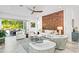 Open living area with stylish seating, unique wood accent wall and access to outdoor patio at 2327 Hillview St, Sarasota, FL 34239