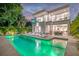 Backyard view of a modern home featuring a pool, lounge chairs, a dining area and balconies at 2327 Hillview St, Sarasota, FL 34239