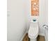Simple powder room with wood-look floors, a standard toilet, and minimalist decor at 2327 Hillview St, Sarasota, FL 34239