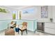 Bright sitting area with two wicker chairs, a beverage fridge, and a view of the surrounding trees at 2327 Hillview St, Sarasota, FL 34239