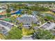 Aerial view of community center featuring tennis courts, a lake, pool, trees and multiple parking spaces at 2334 Felicity Pl, North Port, FL 34289