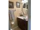 Comfortable bathroom with neutral walls, dark vanity, framed art, decorative towels, and oval mirror at 2334 Felicity Pl, North Port, FL 34289