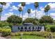 Lakeside Plantation entrance sign surrounded by green foliage, various flowers and tall palm trees at 2334 Felicity Pl, North Port, FL 34289