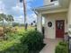 Charming front door with round window detail, and beautiful landscaping, and lawn views at 2334 Felicity Pl, North Port, FL 34289
