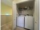 Laundry room featuring a washer, dryer, tile flooring, shelving and white walls at 2334 Felicity Pl, North Port, FL 34289